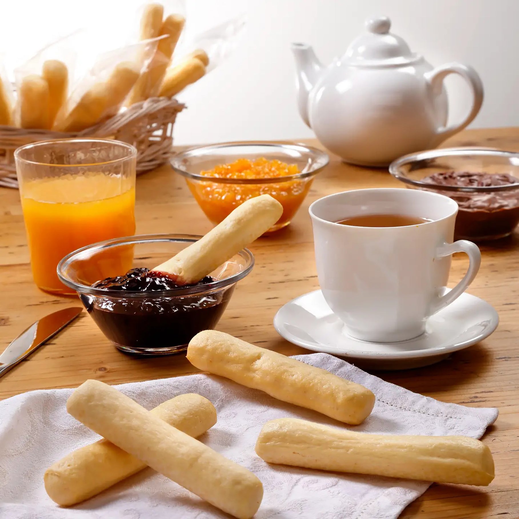 I Macoritti mini breadsticks served at breakfast with tea, orange juice, and assorted fruit jams
