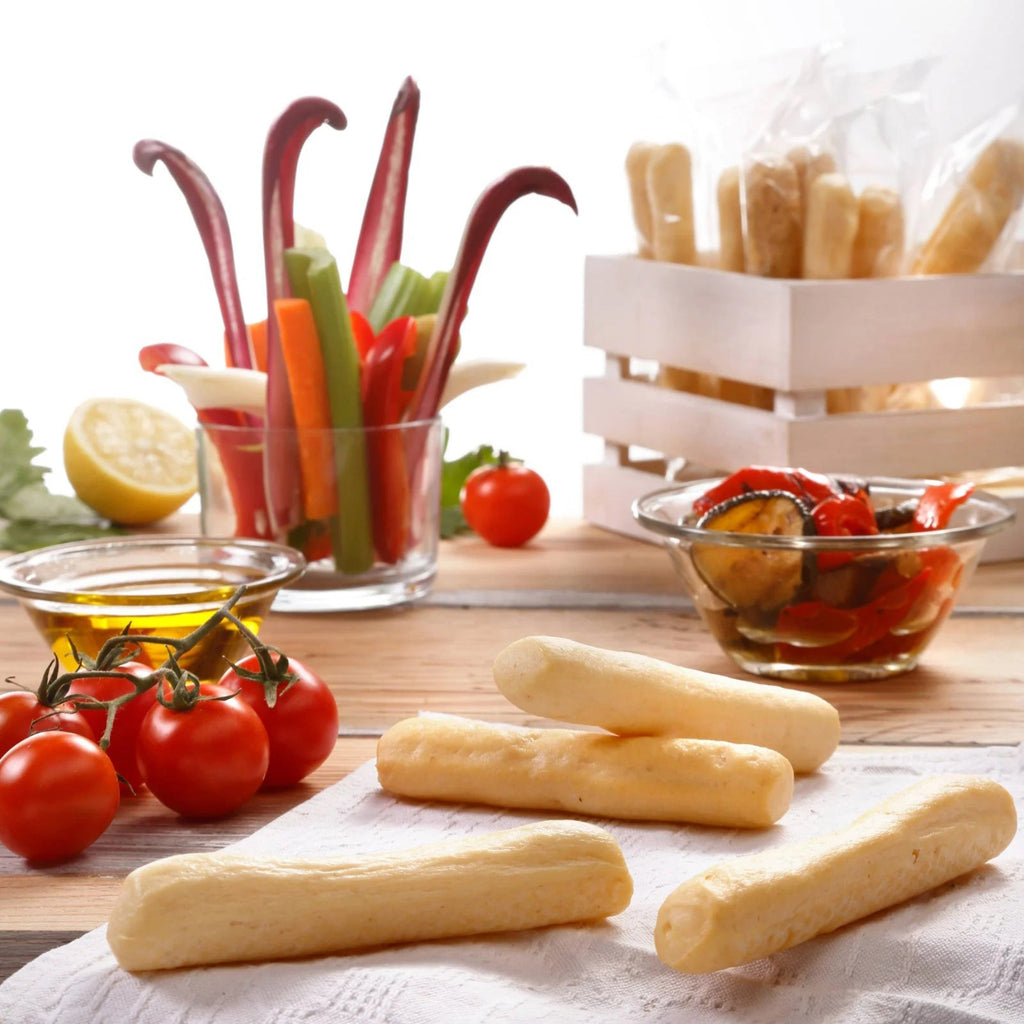 I Macoritti mini breadsticks served with cherry tomatoes, fresh vegetables, and olive oil on wooden table